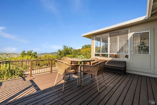 wooden deck featuring outdoor dining area and a mountain view