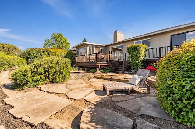 view of yard with a patio, a wooden deck, and a sunroom