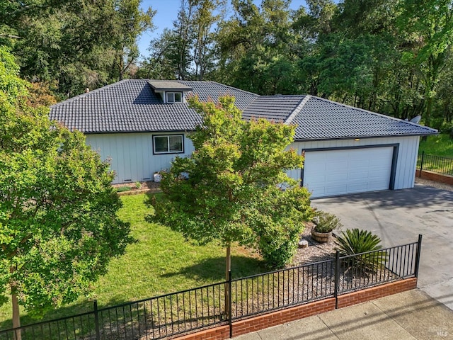 view of front of property with driveway, a tile roof, board and batten siding, and a garage