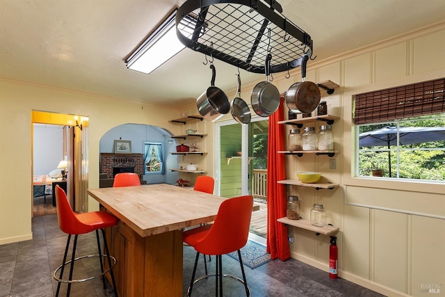 10 Wildwood Ln, Cazadero, CA 95421 - kitchen with a fireplace, ornamental molding, open shelves, butcher block counters, and baseboards