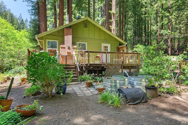 10 Wildwood Ln, Cazadero, CA 95421 - view of front of house with board and batten siding, a wooden deck, stairway, and a view of trees