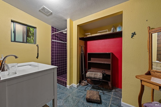 10 Wildwood Ln, Cazadero, CA 95421 - clothes washing area with a sink, a textured ceiling, dark tile patterned flooring, and a textured wall
