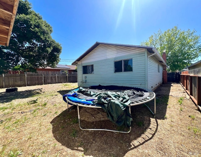 rear view of house featuring a fenced backyard