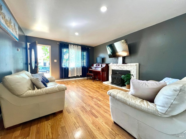 living room featuring light wood-style flooring, recessed lighting, and a fireplace
