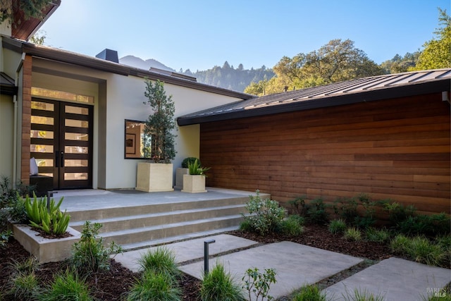 421 Crown Rd, Kentfield, CA 94904 - view of exterior entry with a standing seam roof, stucco siding, metal roof, and french doors