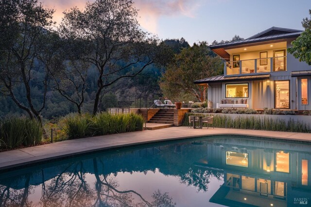 421 Crown Rd, Kentfield, CA 94904 - exterior entry at dusk featuring a standing seam roof, stucco siding, and metal roof