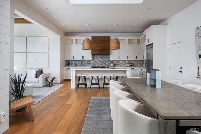 421 Crown Rd, Kentfield, CA 94904 - kitchen with a kitchen bar, a kitchen island, light wood-style floors, backsplash, and recessed lighting