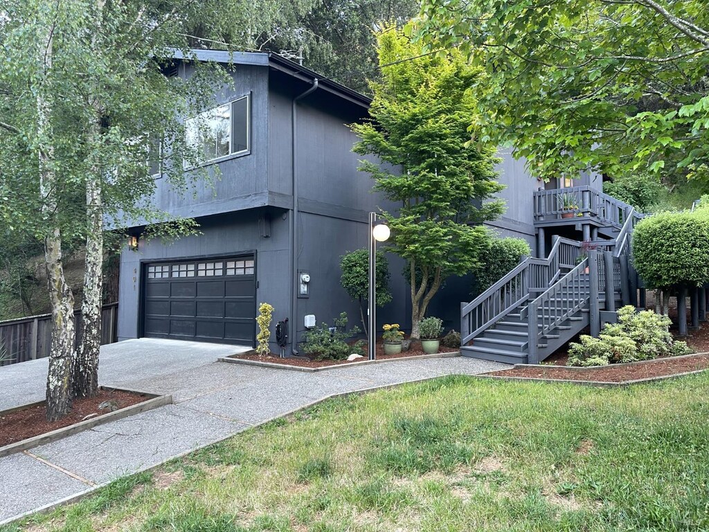 401 Sausalito St, Corte Madera, CA 94925 - view of front of home with concrete driveway, stairs, a garage, and a front lawn