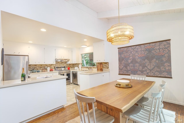 dining space featuring light wood finished floors, recessed lighting, and a chandelier