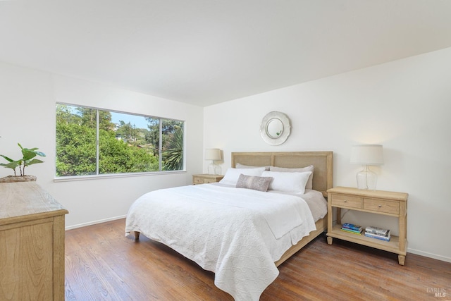 bedroom with wood finished floors and baseboards