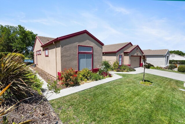 573 Laurel Pl, Rio Vista, CA 94571 - ranch-style house with stucco siding, a front yard, driveway, and an attached garage