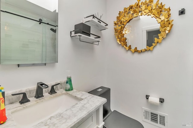 bathroom featuring toilet, an enclosed shower, and vanity