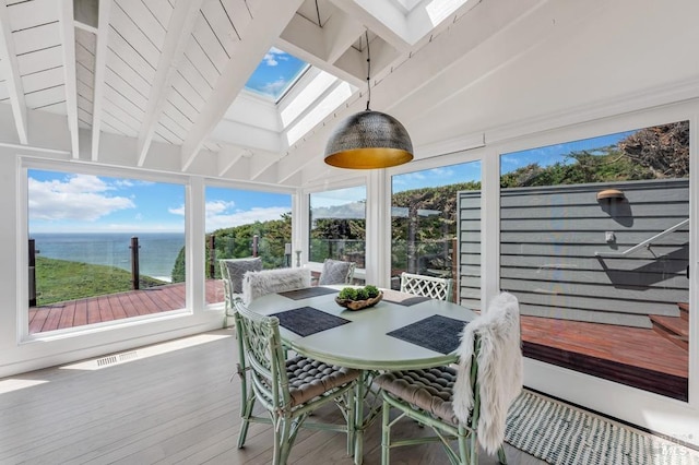 sunroom with a skylight, wood finished floors, plenty of natural light, and a deck with water view