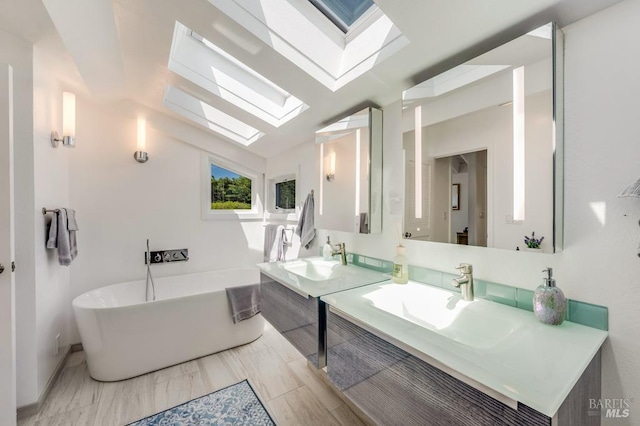 bathroom with a skylight, a soaking tub, and vanity