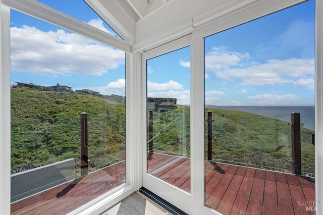 unfurnished sunroom featuring a water view and wood finished floors