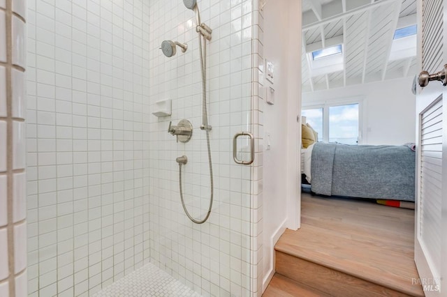 full bath featuring ensuite bath, wood finished floors, and a tile shower
