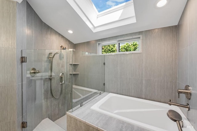 full bath with tiled shower and a bath