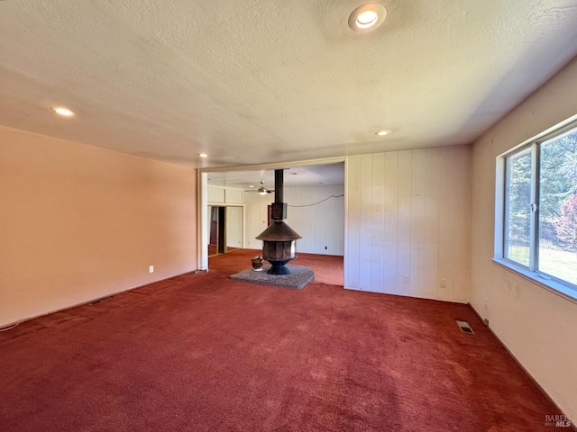 4511 Dry Creek Rd, Napa, CA 94558 - unfurnished living room featuring a wood stove, carpet floors, a textured ceiling, and recessed lighting