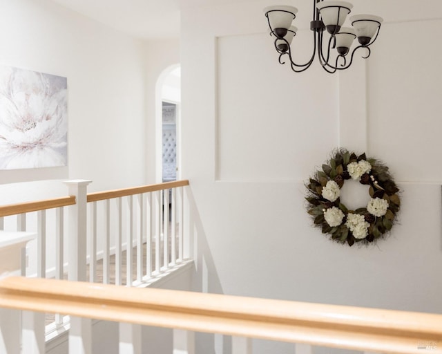 hallway featuring arched walkways and a chandelier
