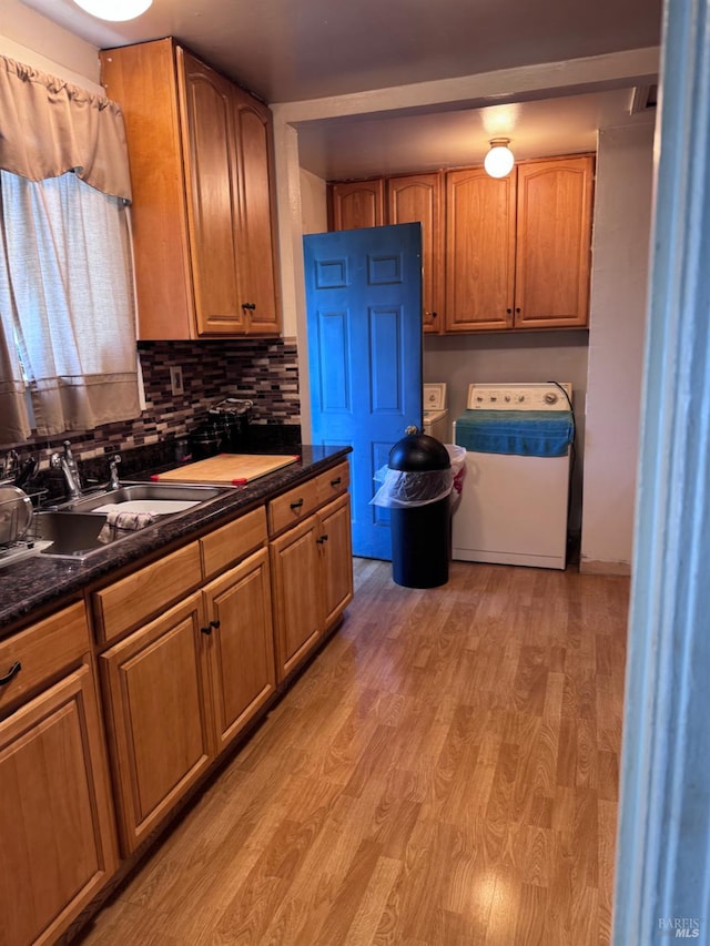 812 Grant St, Vallejo, CA 94590 - kitchen featuring washer / dryer, light wood-style floors, dark countertops, a sink, and backsplash