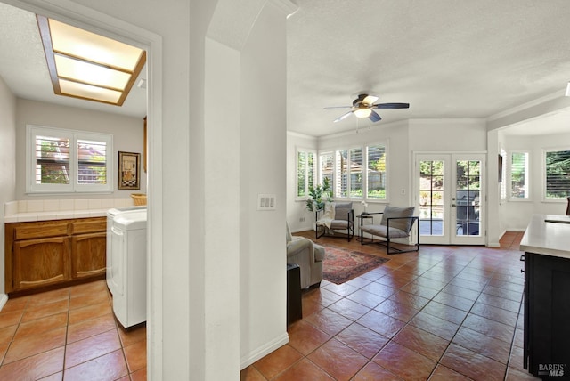 sunroom / solarium with washer / clothes dryer, french doors, and healthy amount of natural light