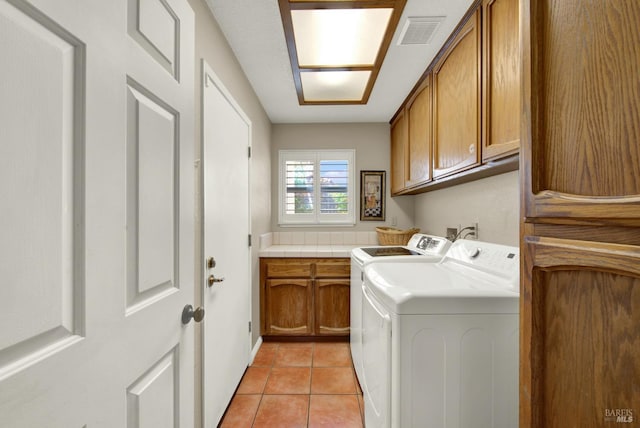 laundry area with cabinet space, washing machine and clothes dryer, and light tile patterned flooring