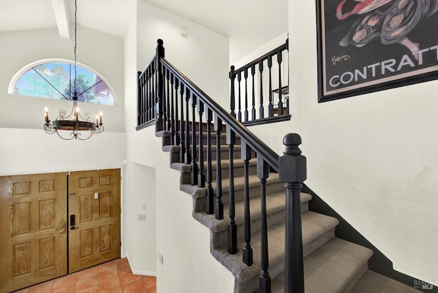 stairway with a chandelier, high vaulted ceiling, beamed ceiling, tile patterned flooring, and baseboards