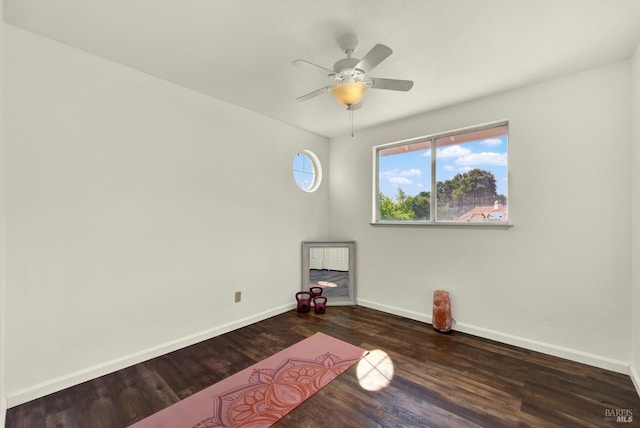 empty room featuring baseboards, wood finished floors, and a ceiling fan
