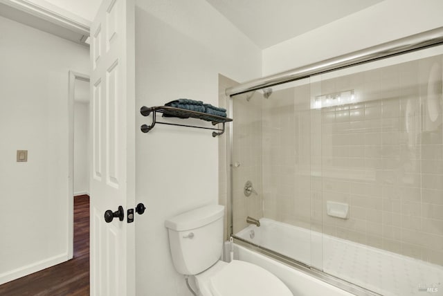 full bath featuring baseboards, wood finished floors, toilet, and enclosed tub / shower combo