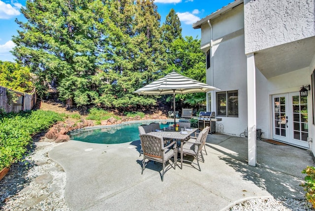 view of swimming pool featuring french doors, a patio area, fence, grilling area, and outdoor dining area