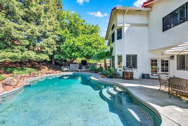 outdoor pool featuring french doors and a patio