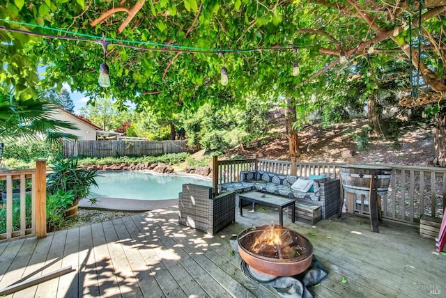 wooden deck featuring an outdoor living space with a fire pit and a fenced backyard