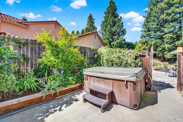 view of patio featuring a hot tub and a fenced backyard