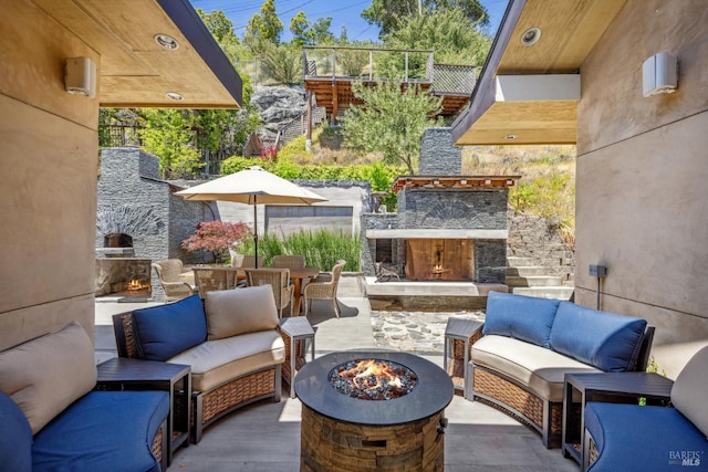view of patio featuring an outdoor living space with a fireplace and outdoor dining space