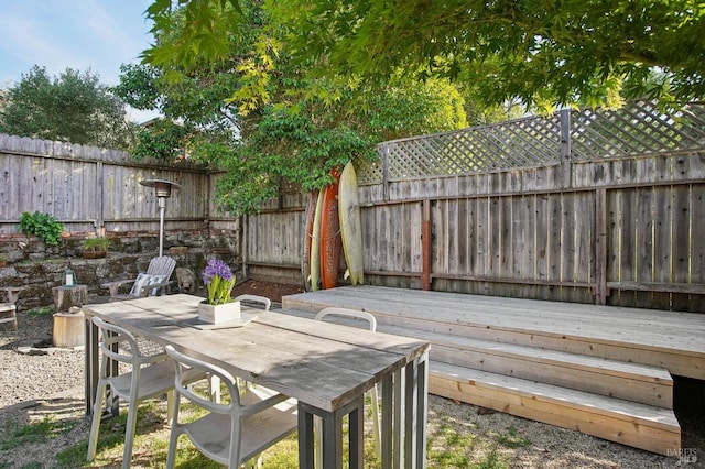 wooden deck featuring a fenced backyard, outdoor dining space, and a patio