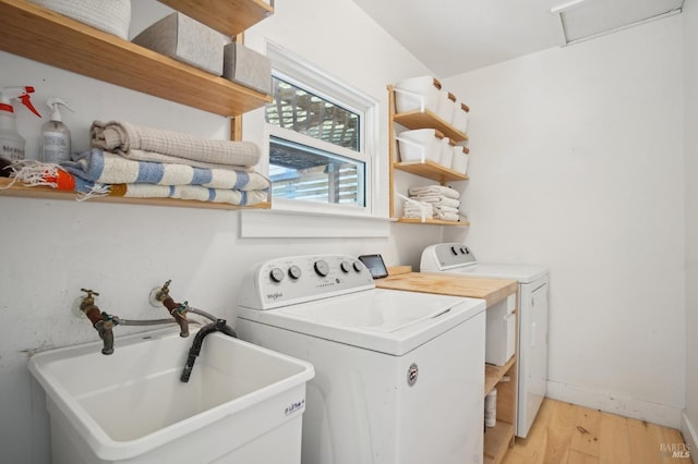 laundry room featuring washer and clothes dryer, light wood finished floors, and attic access