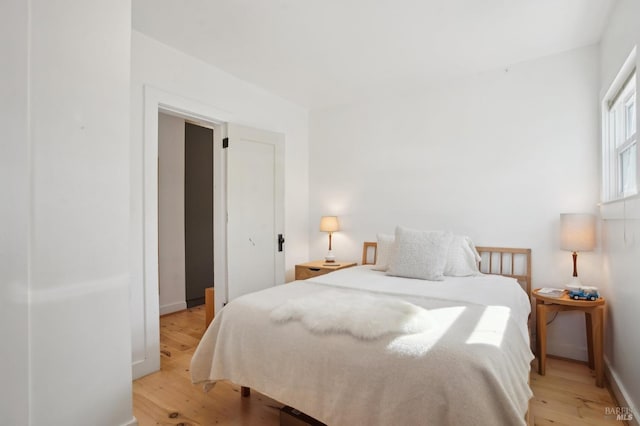 bedroom featuring light wood-style floors and baseboards