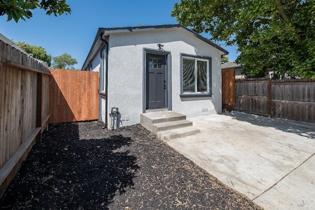 513 Verde Ave, Richmond, CA 94801 - rear view of house with stucco siding, a fenced backyard, entry steps, and a patio