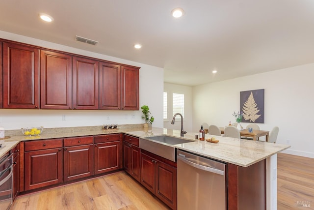 kitchen featuring stainless steel appliances, dark brown cabinets, a sink, a peninsula, and recessed lighting