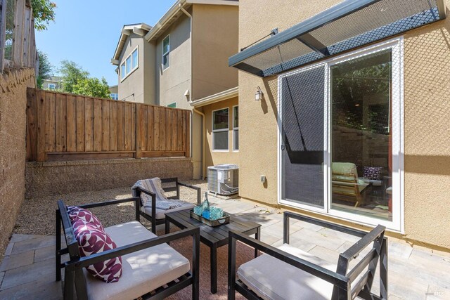 view of patio / terrace with central AC unit, fence, and outdoor lounge area