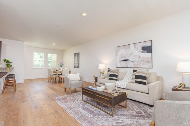 living area featuring light wood finished floors, baseboards, and recessed lighting