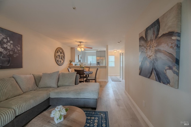 living room featuring wood finished floors, ceiling fan, and baseboards