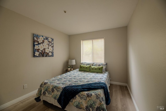 bedroom featuring wood finished floors and baseboards