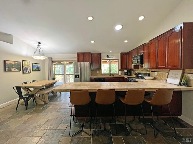 3320 Booth Way, Potter Valley, CA 95469 - kitchen with black appliances, vaulted ceiling, decorative backsplash, a peninsula, and stone tile floors