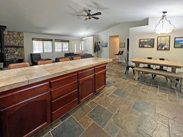 3320 Booth Way, Potter Valley, CA 95469 - kitchen featuring a ceiling fan, stone tile flooring, lofted ceiling, a wood stove, and open floor plan