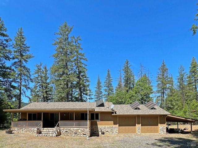 3320 Booth Way, Potter Valley, CA 95469 - view of front facade with stone siding, a porch, an attached garage, gravel driveway, and a shingled roof