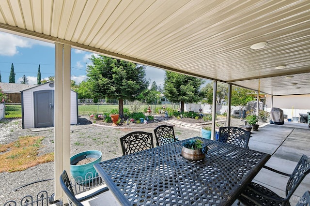 134 Lassen Cir, Vacaville, CA 95687 - view of patio featuring outdoor dining space, a storage unit, a fenced backyard, and an outbuilding
