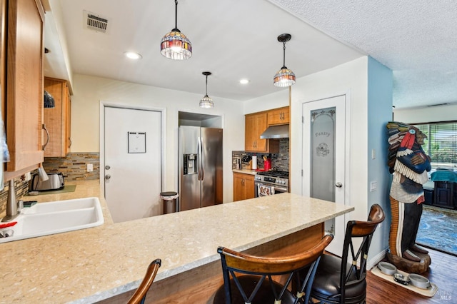 134 Lassen Cir, Vacaville, CA 95687 - kitchen with stainless steel appliances, under cabinet range hood, a peninsula, a sink, and backsplash