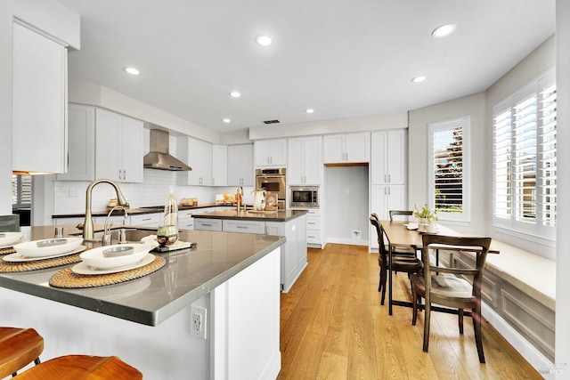 653 Robinson Way, Benicia, CA 94510 - kitchen with wall chimney range hood, dark countertops, appliances with stainless steel finishes, white cabinets, and recessed lighting