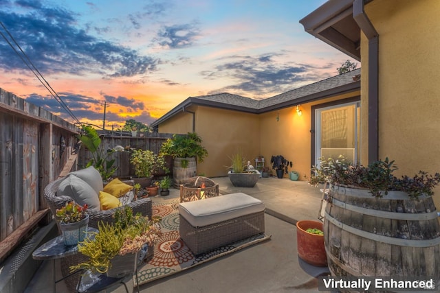patio terrace at dusk featuring an outdoor hangout area and fence